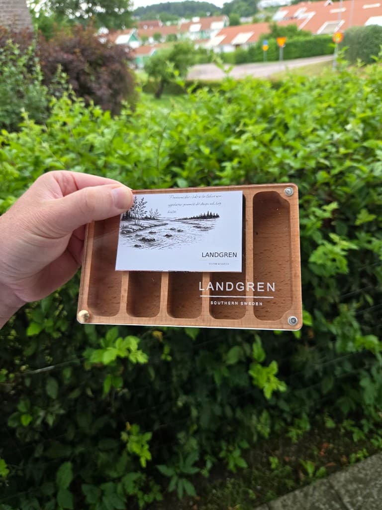 Hand som håller en Landgren-ask med transparent lock